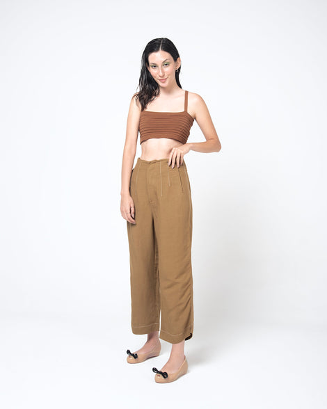 Model in a brown outfit wearing a pair of beige Ultragirl Bow flats with black bow