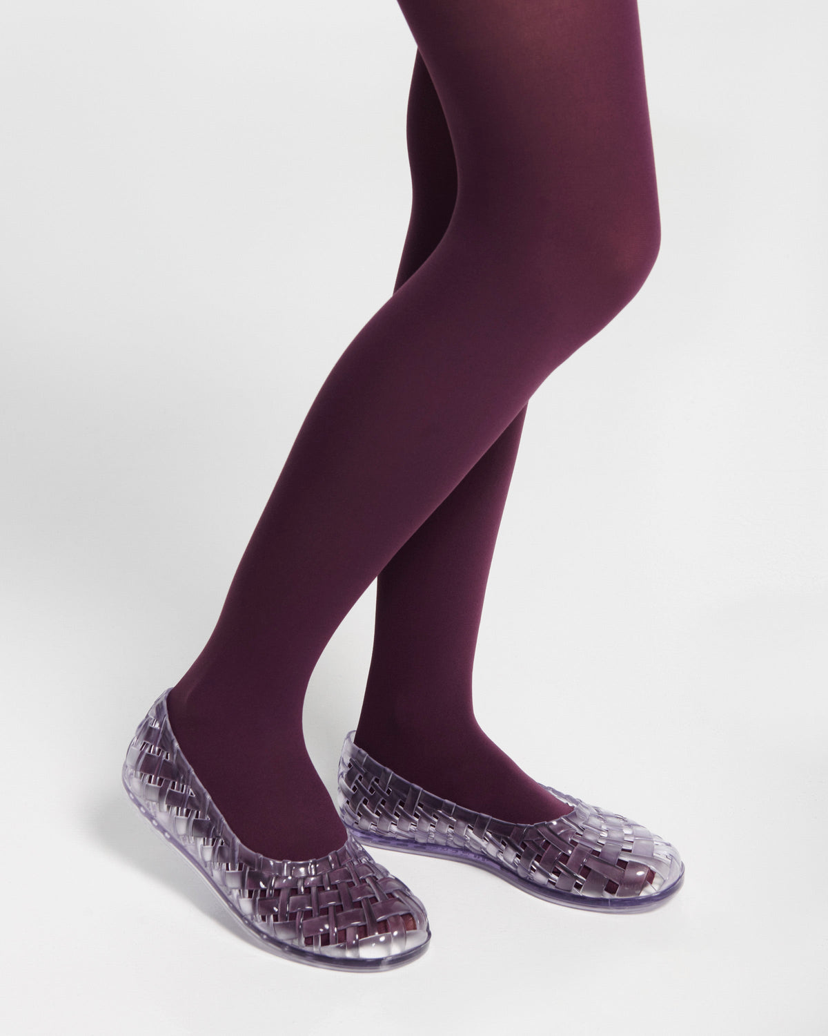 Model's legs in purple tights wearing a pair of clear Possession Ballerina flats