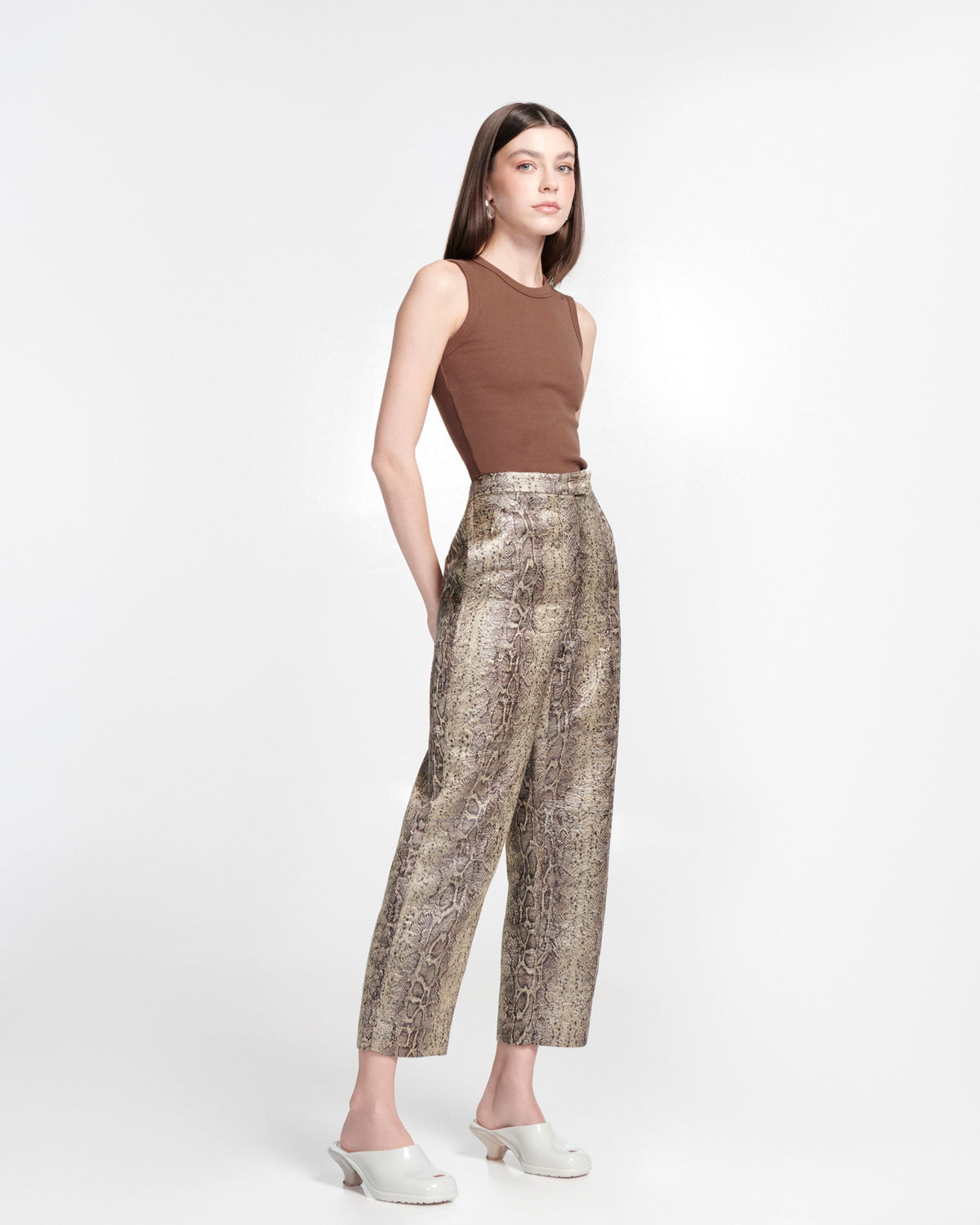 Model in snake print pants and brown tank top wearing a pair of light beige Gaia kitten heels with peep toe