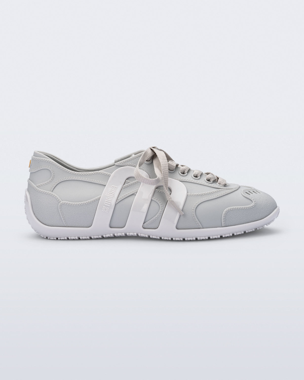 Side view of a grey Motion sneaker with white colored sole and M monogram