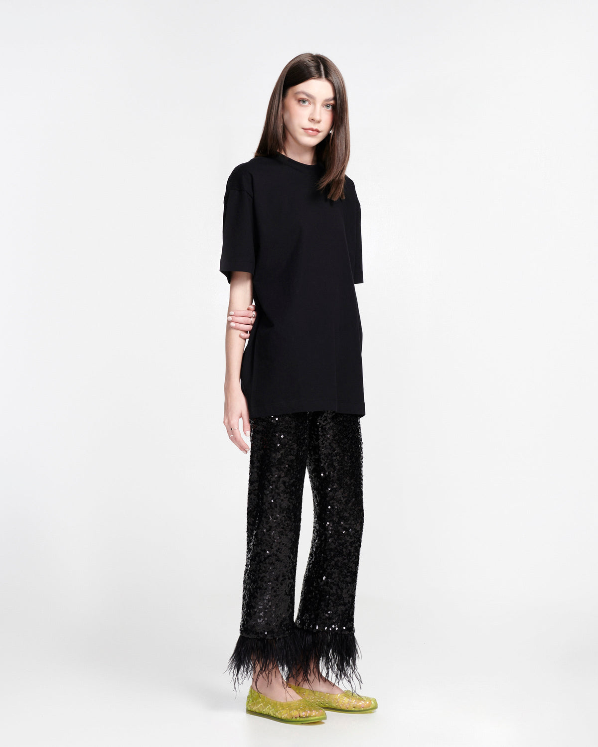 Model in black pants and shirt wearing a pair of clear green Possession Ballerina flats