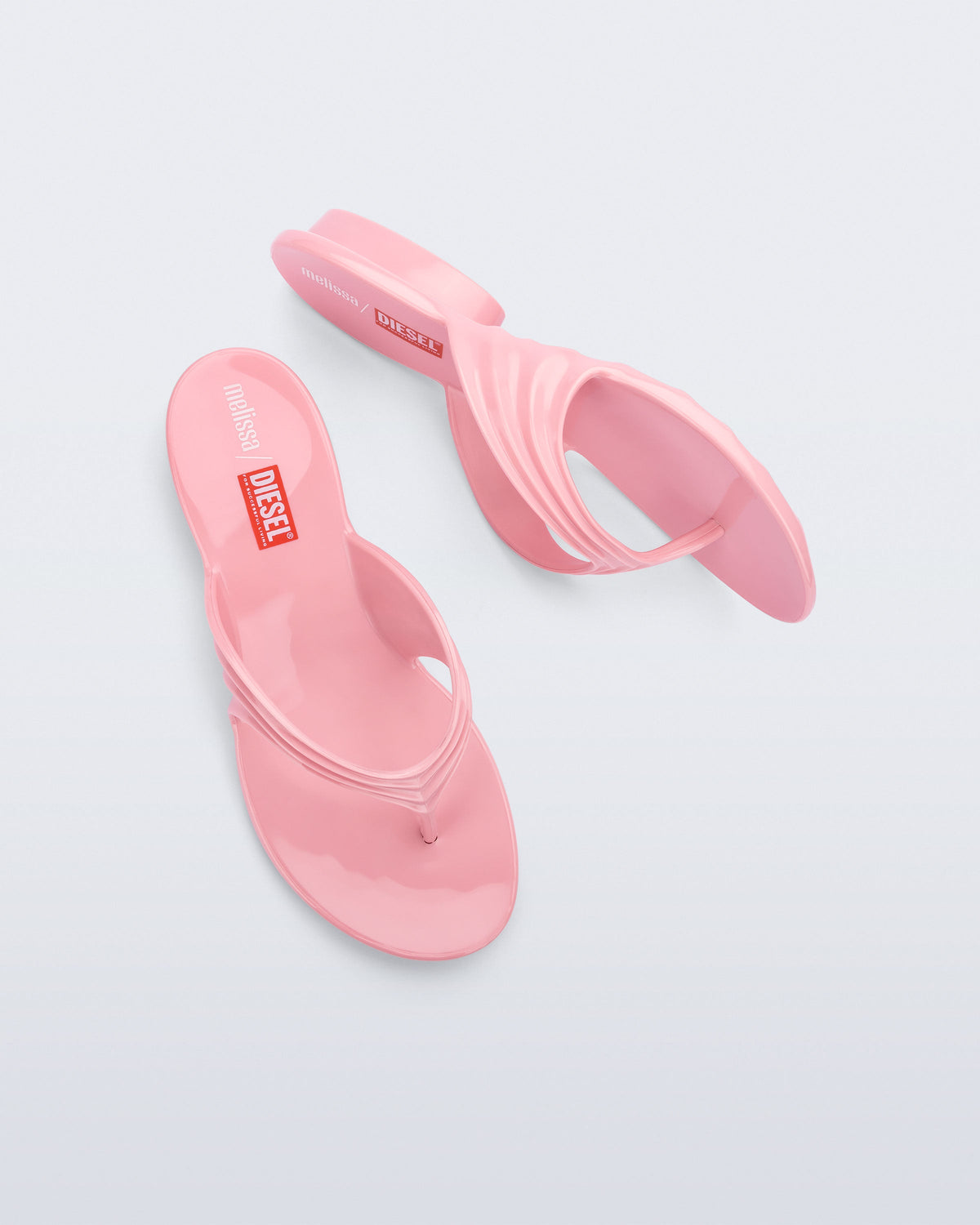 Top and side view of a pair of pink Flip Flop + Diesel sandals