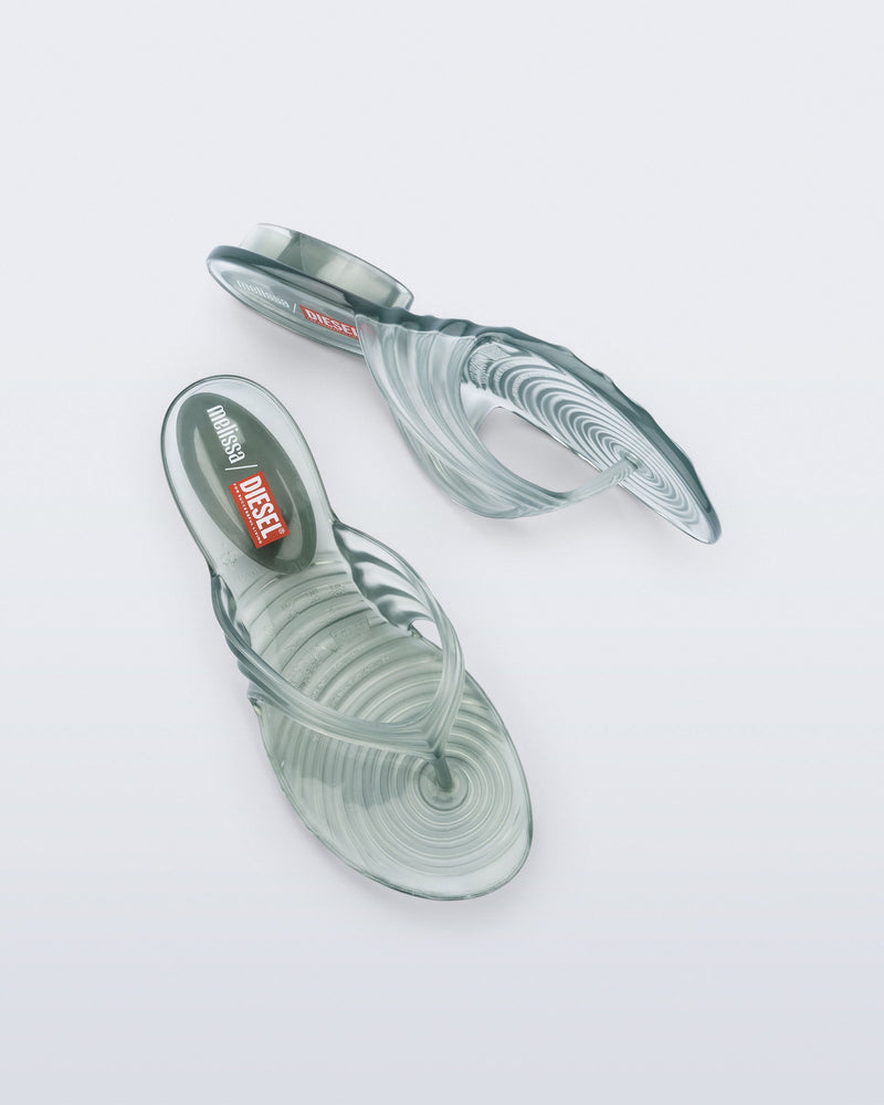 Top and side view of a pair of transparent green Flip Flop + Diesel sandals