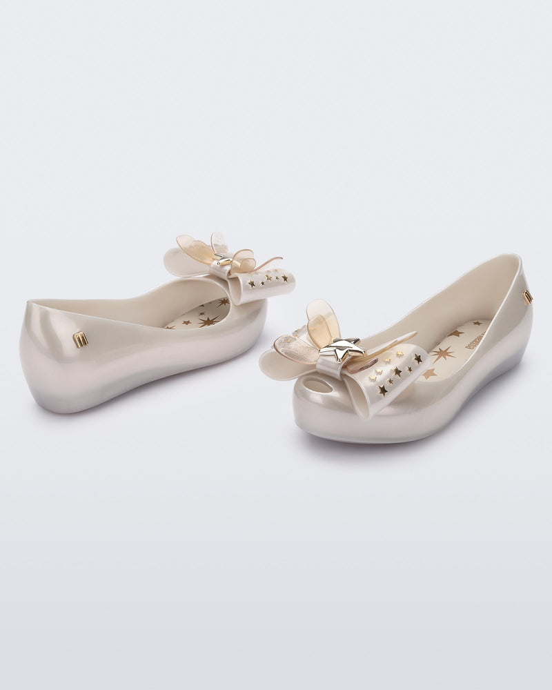 Angled view of a pair of Mini Melissa Ultragirl peeptoe ballet flats in white with star printed butterfly bow applique.