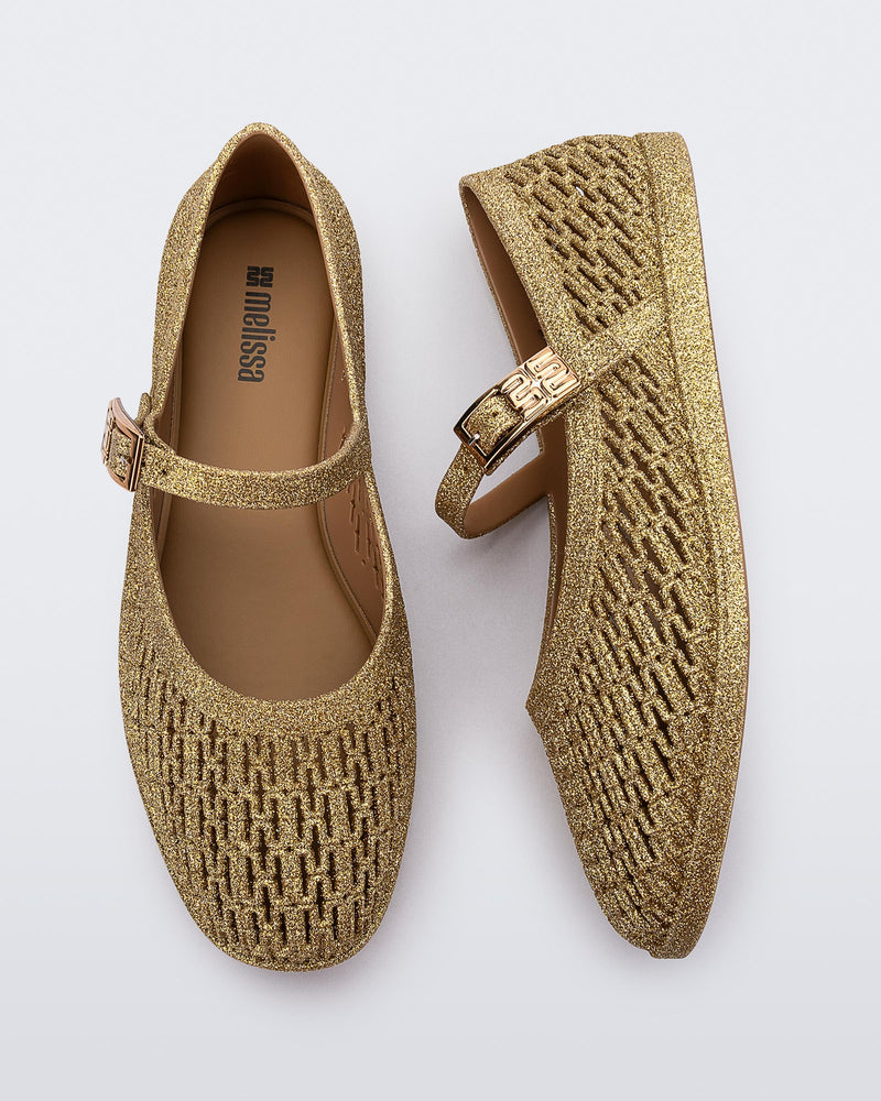 Top and side view of a pair of beige glitter Harper flat with strap