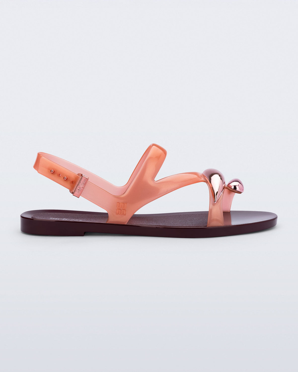 Side view of an orange Iris sandal with burgundy sole and rose gold upper embellishments
