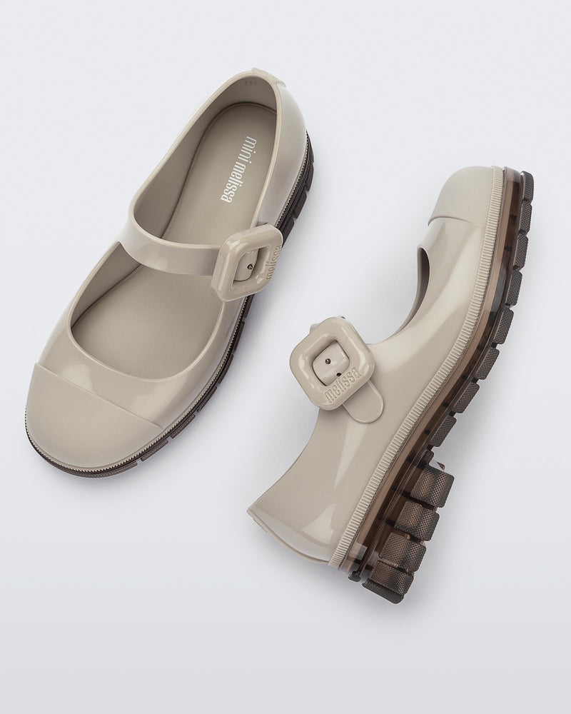 Top and side view of a pair of beige with brown sole June kids mary janes with matte toe cap