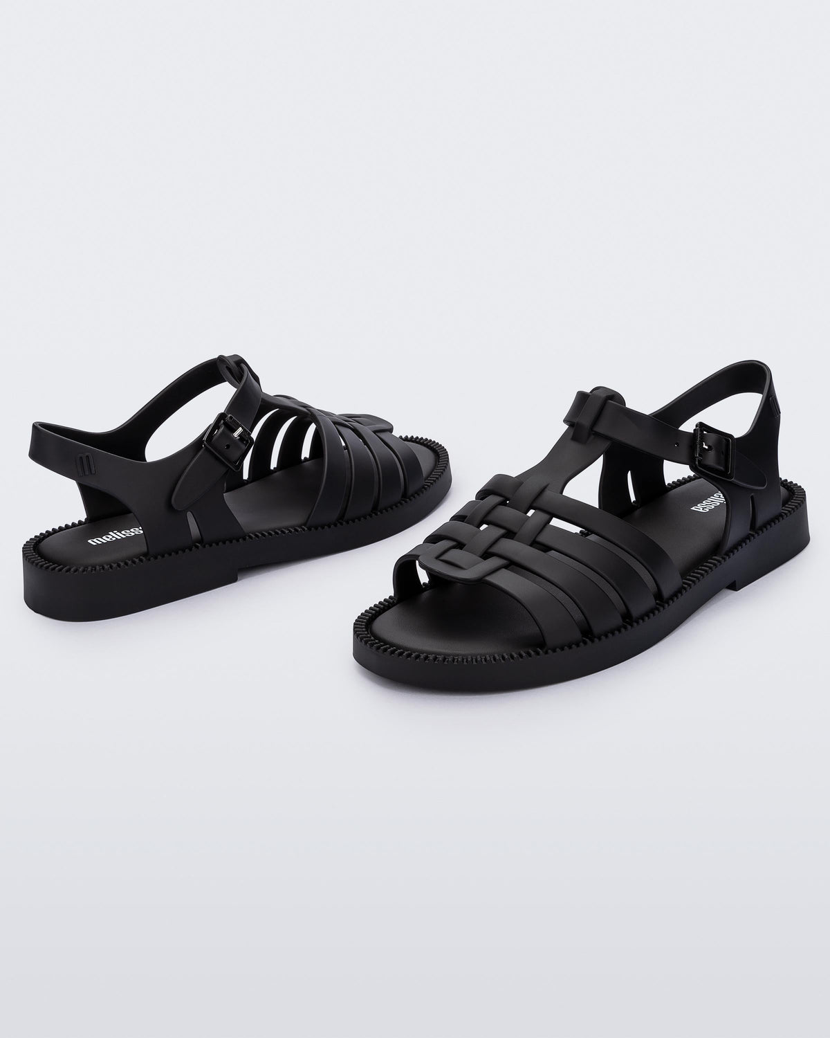 Angled view of a pair of matte black Possession Fresh fisherman style sandals with open toe.