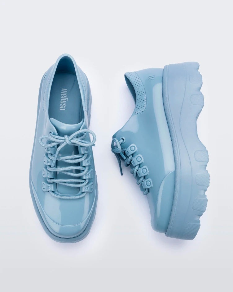 A top and side view of a pair blue platform Melissa Kick Off Sneakers with laces.