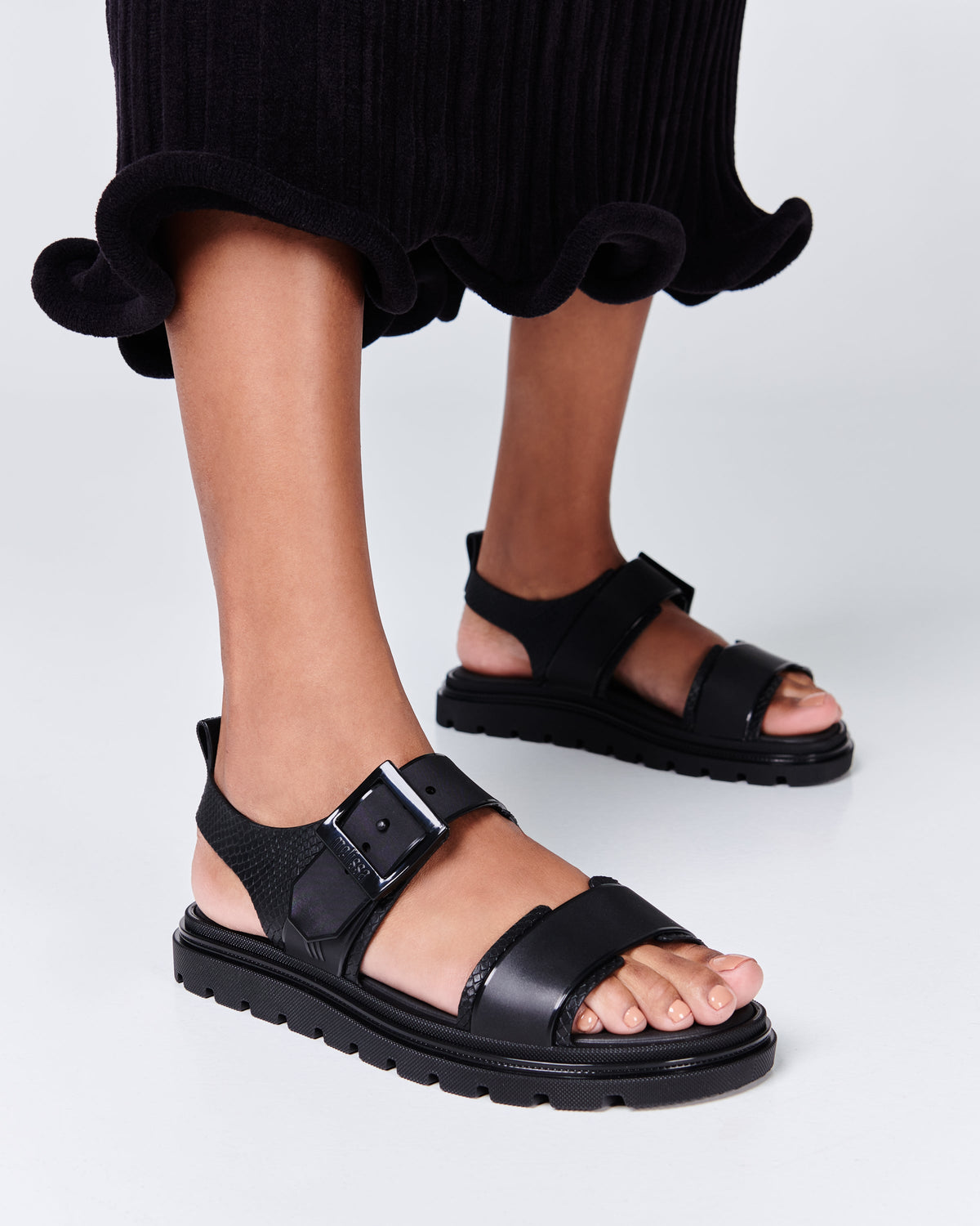 Model's legs in a pair of black Connection Papete sandals