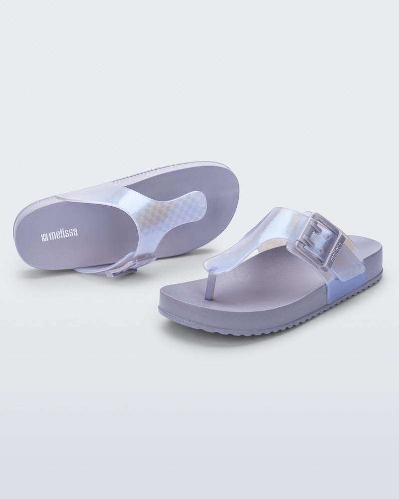 Top and angled view of a pair of pearly blue Cozy Flip flops
