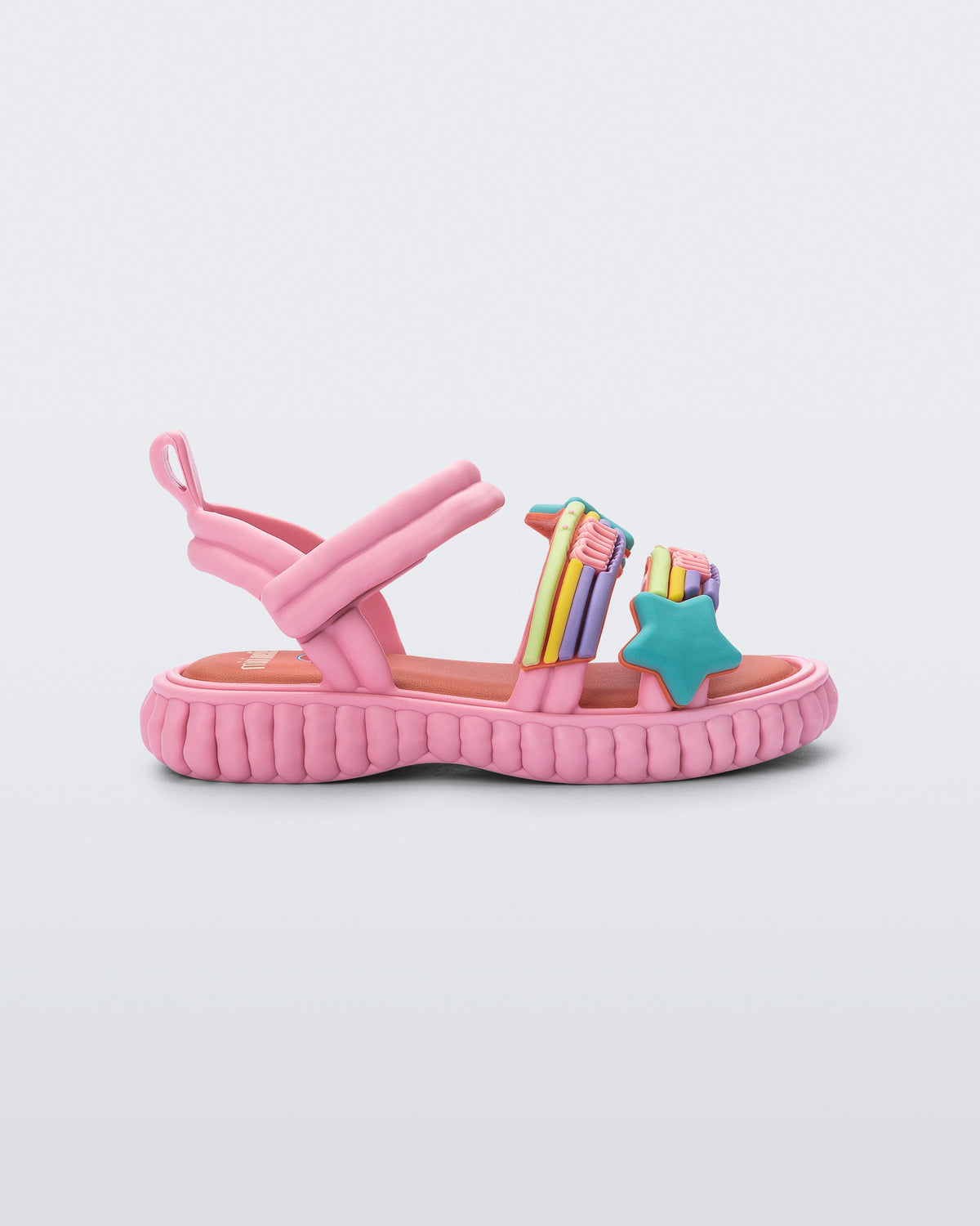 Side view of a pink Create + Play Doh sandal with rainbow and a star straps