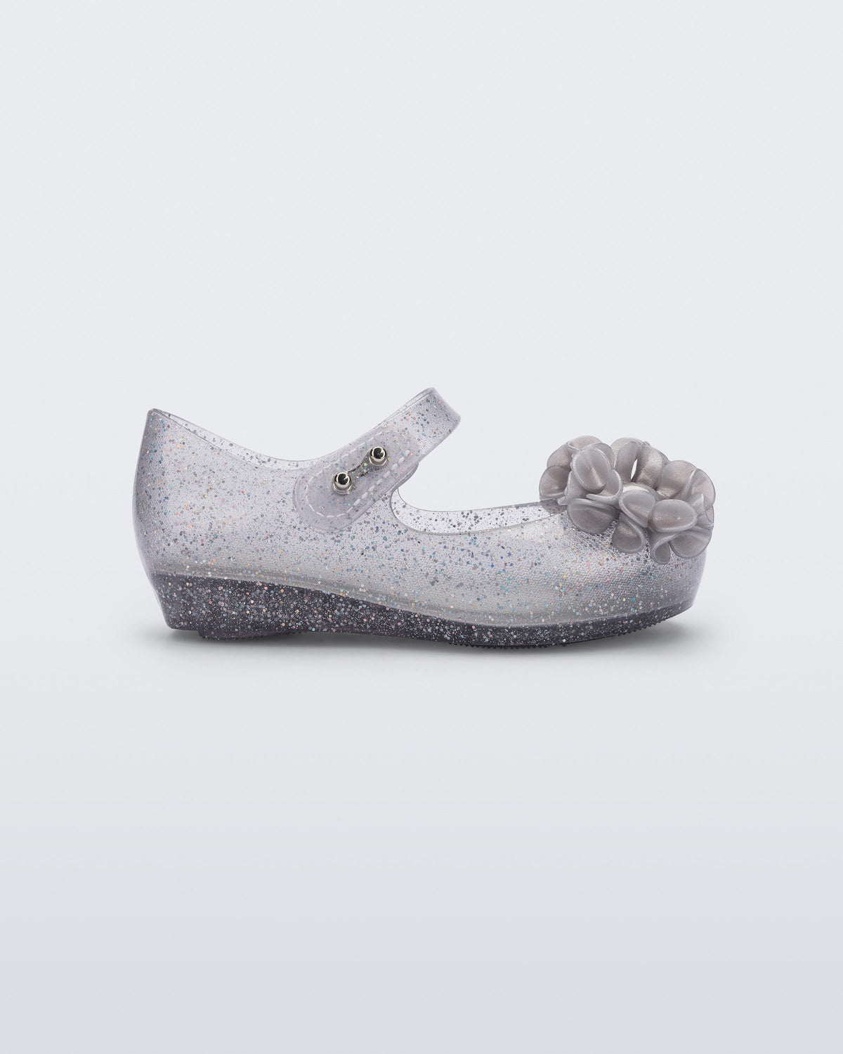 Side view of a clear grey glitter Ultragirl Springtime baby flat with grey flower and peep toe.