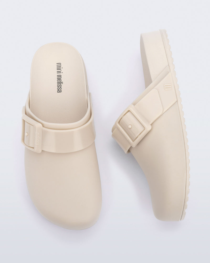 Top and side view of a pair of beige kids Cozy Clogs