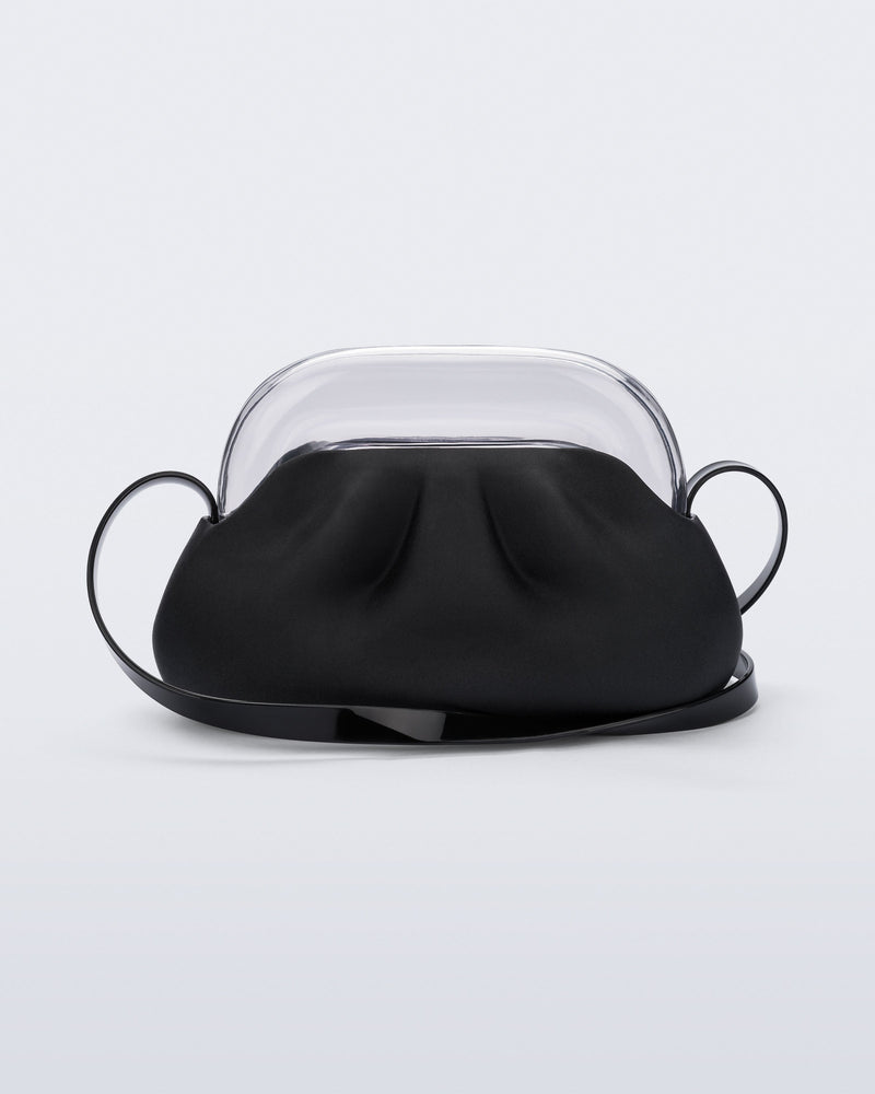 Back view of a small black bag with clear clutch and long strap