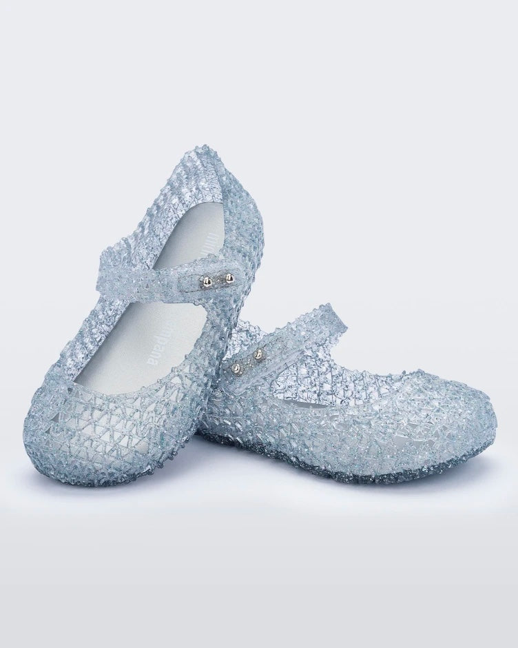 Angled view of a pair of Mini Melissa Campana flats in clear for baby with an open woven texture.