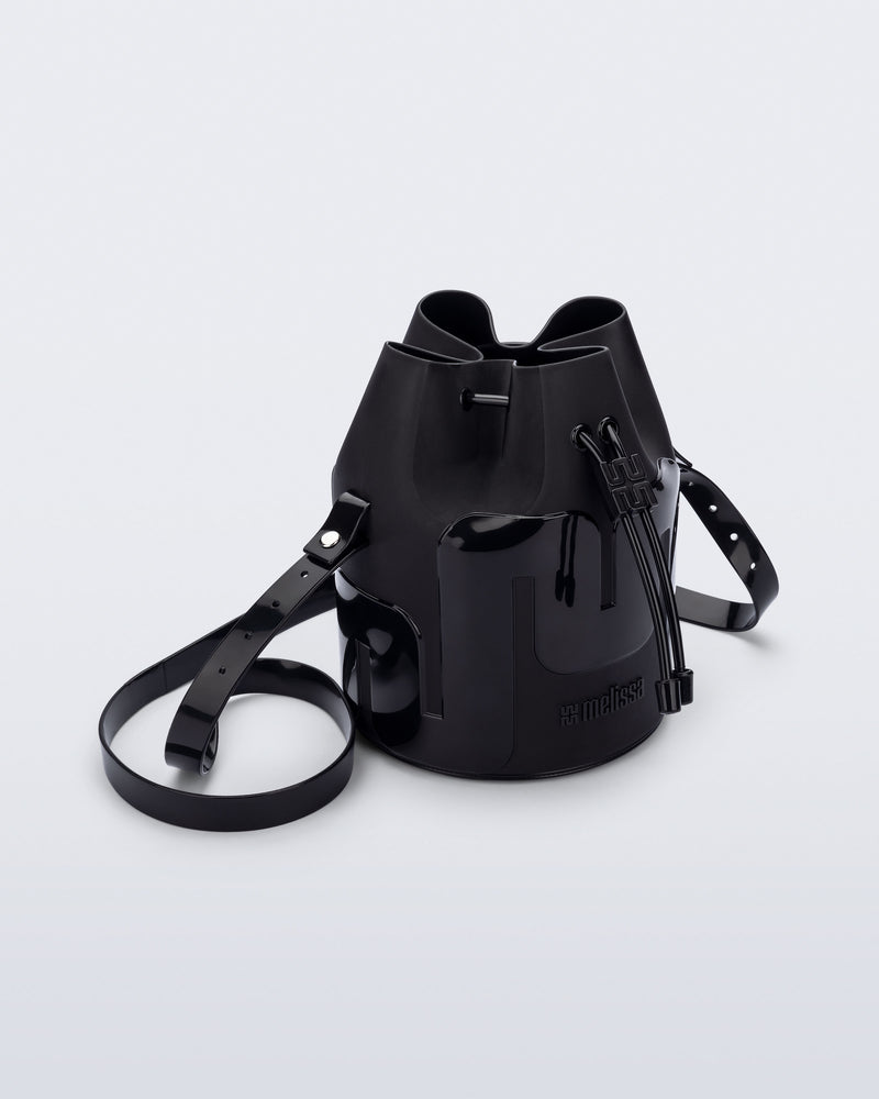 Angled view of a Melissa Station bucket bag in Black. The bag has an adjustable shoulder strap and a drawstring top closure.