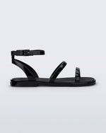 Side view of the Melissa Heat Sandal. This is a flat sandal with a multiple straps, one across the toes, mid part of the foot, and a buckle strap around the ankle with a supporting strap that connects the ankle strap to the sole of the shoe. The straps, insole, outsole, and buckles on the ankle strap are black. The insole is embossed with a geometric pattern.