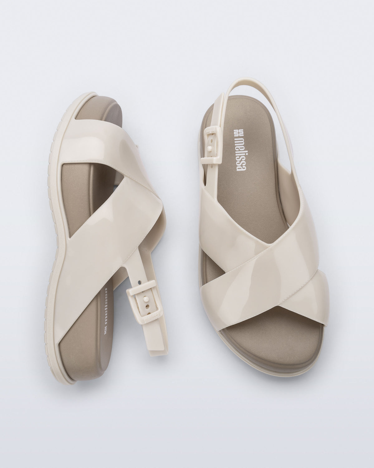 Top and side view of a pair of Melissa Mare platform sandals. This sandal has two cross straps across the front part of the foot with a thin buckle strap attached. The straps and outsole are beige while the platform insole is a darker beige.