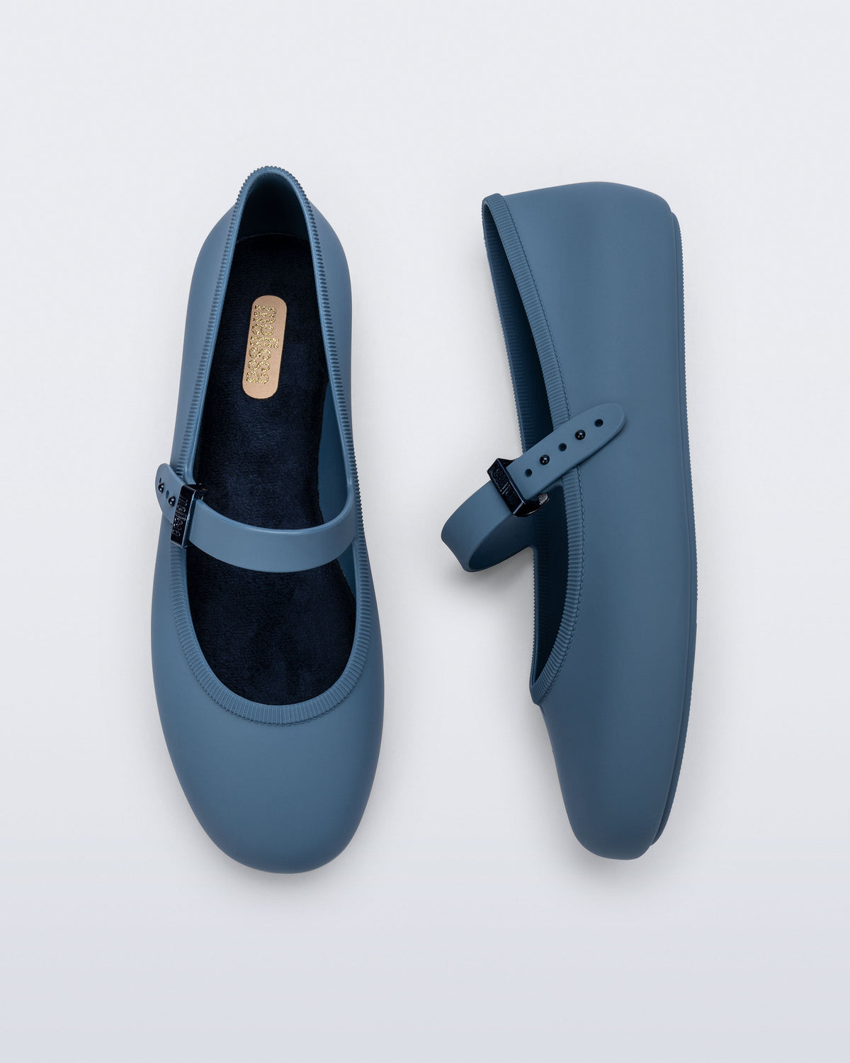 Side and top view of a pair of blue Soft Ballerina flats with top buckle strap