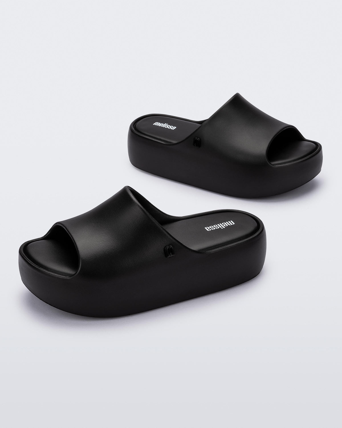 Angled view of a pair of black Free Platform women's slides