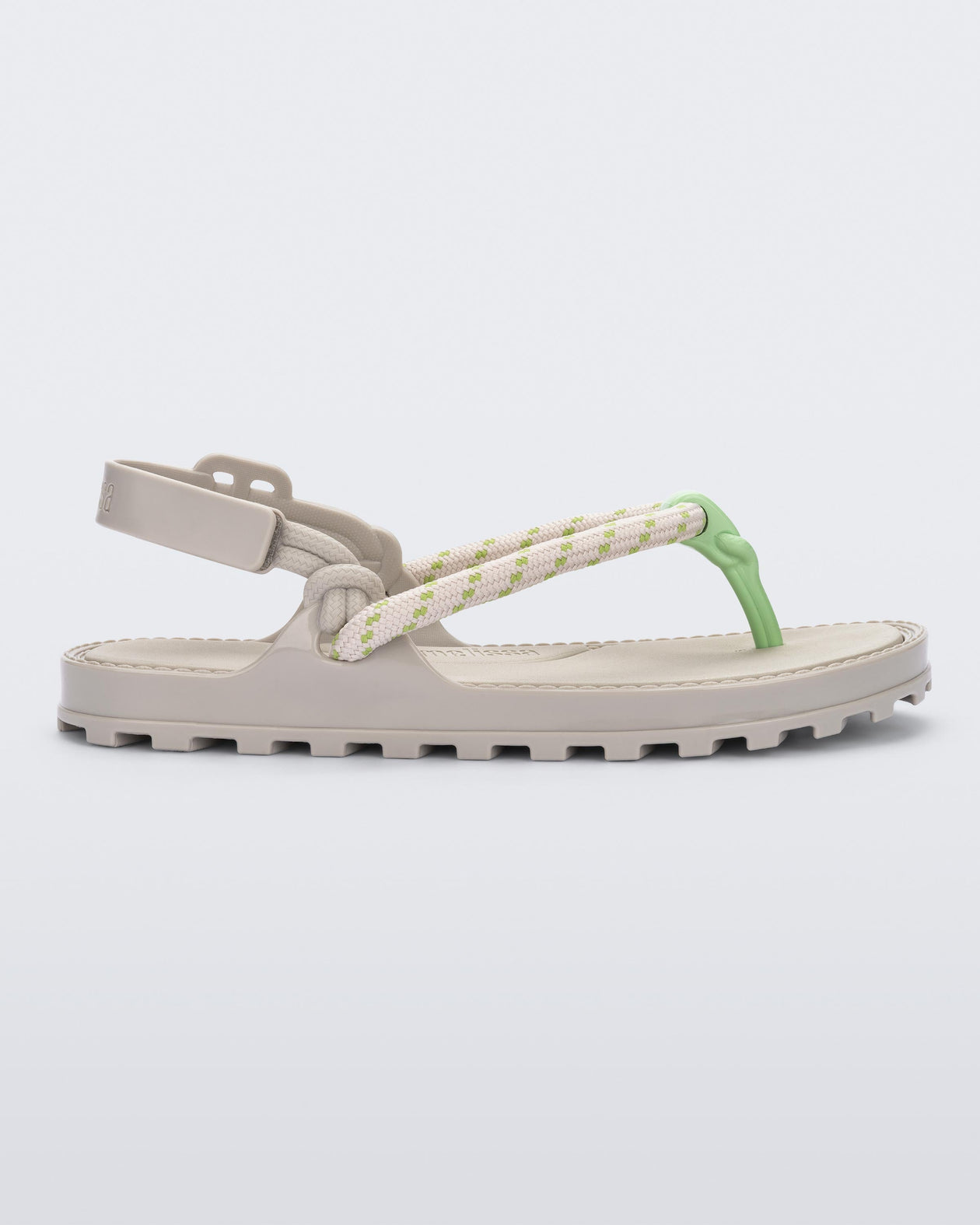 Side view of a beige Bond sandal with textile strap and green toe piece
