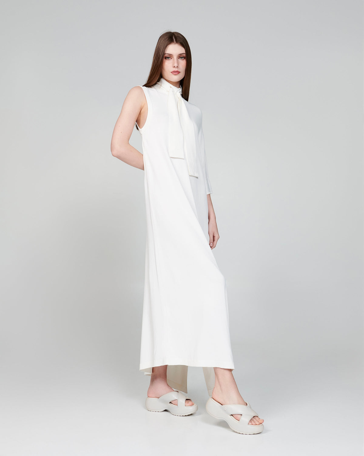 Model in a white dress wearing a pair of beige Free Rise platform slides