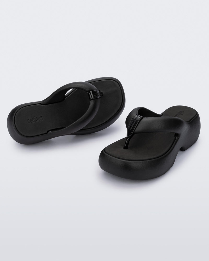 Top and angled view of a pair of black Free Platform II flip flops
