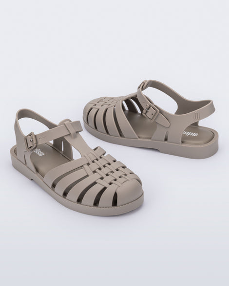 Side angled view of a pair of matte beige Possession adult fisherman style sandal
