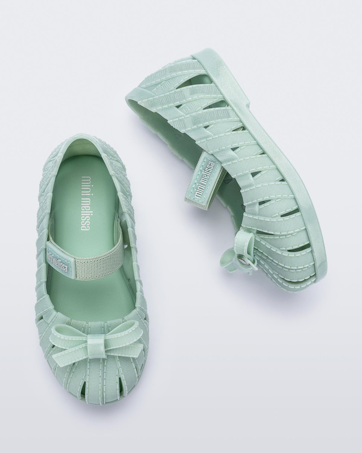 Top and side view of a pair of glitter green M Lover Ballerina baby flat with bow and strap