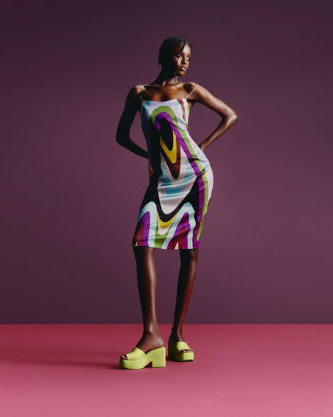 A model posing wearing a pair of Melissa Posh platform slides in Yellow