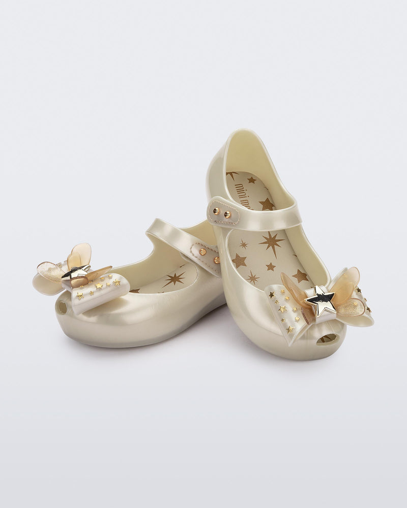 Angled view of a pair of Mini Melissa Ultragirl peeptoe ballet flats for baby in white with star printed butterfly bow applique.