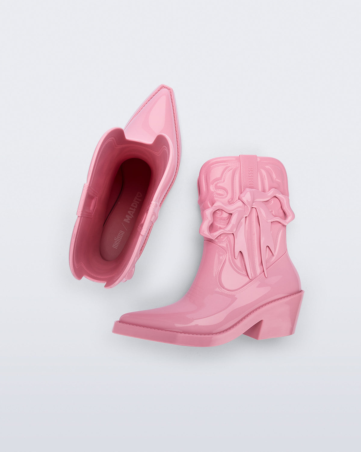 Top and side view of a pair of pink Texas + Maldito boots