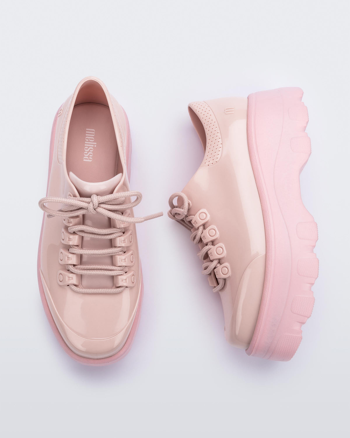 A top and side view of a pair of pink platform Melissa Kick Off Sneakers with laces.