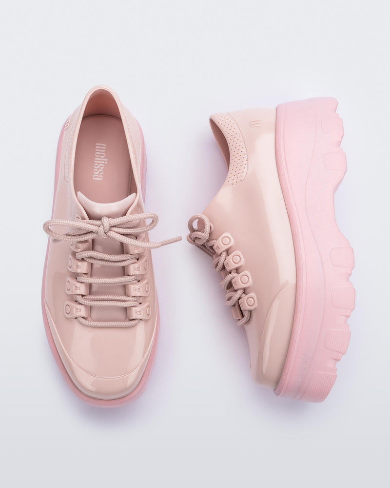 A top and side view of a pair of pink platform Melissa Kick Off Sneakers with laces.