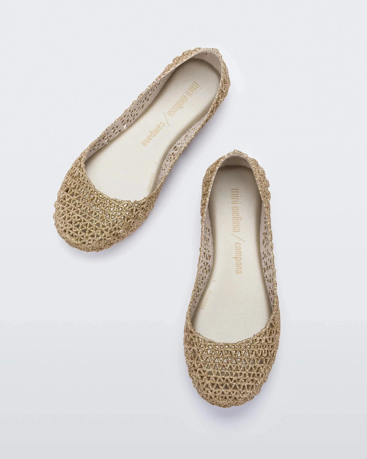 Top view of a pair of white / gold glitter Mini Melissa Campana flats with an open woven texture.