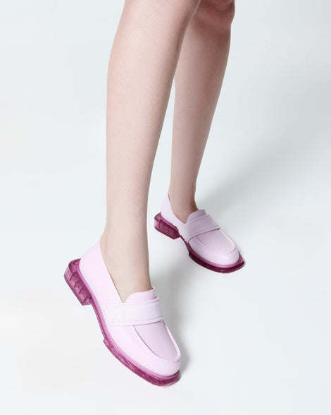 Model's legs wearing a pair of pink Spencer loafers with clear pink soles