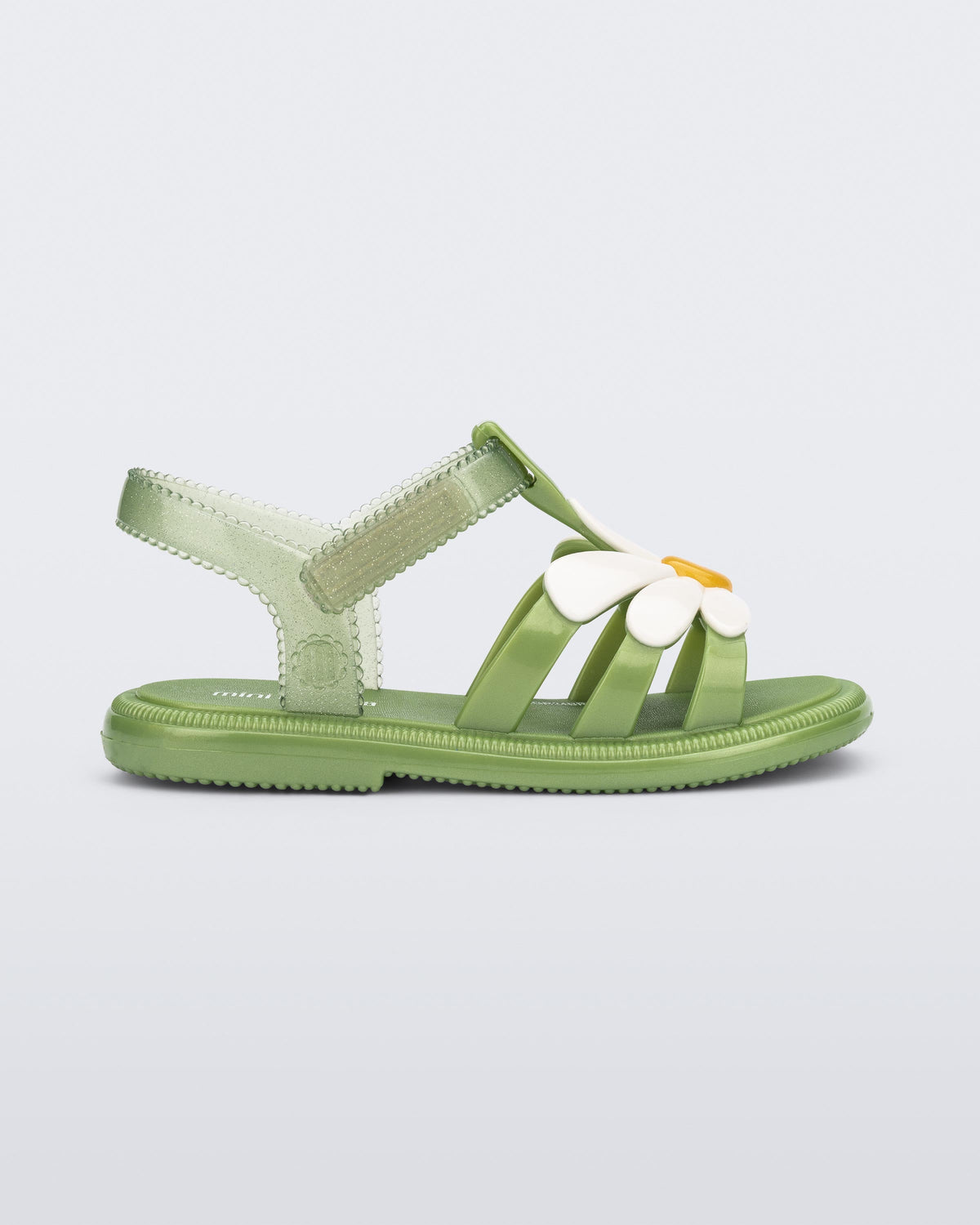 Side view of a green baby Hip Bloomy sandal with a white flower