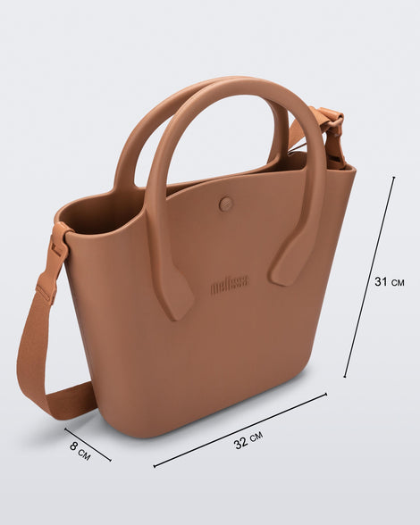 Angled view of a brown Free Big Bag with handles and a strap and dimensions 32 cm length, 8 cm width, 31 cm height