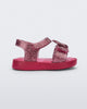 Side view of a glitter pink Mini Melissa Jump sandal with a Mickey Mouse logo detail on the front strap and an ankle strap