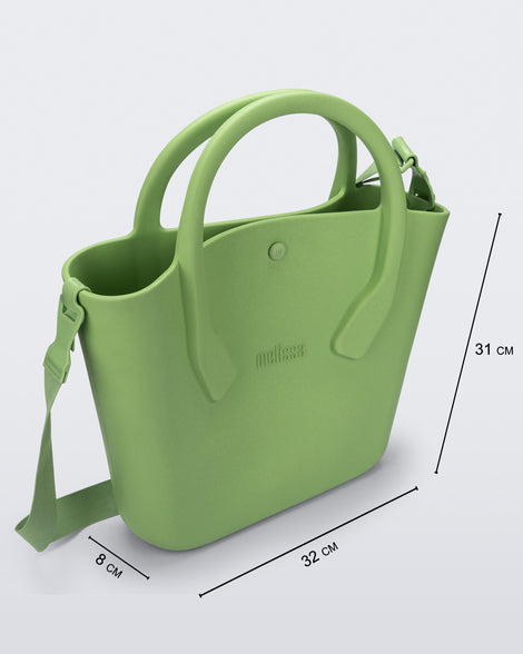 Angled view of a green Free Big Bag with handles and a strap and dimensions 32 cm length, 8 cm width, 31 cm height