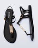 Side and top view of a pair of black Solar M Chic sandals with gold embellishment