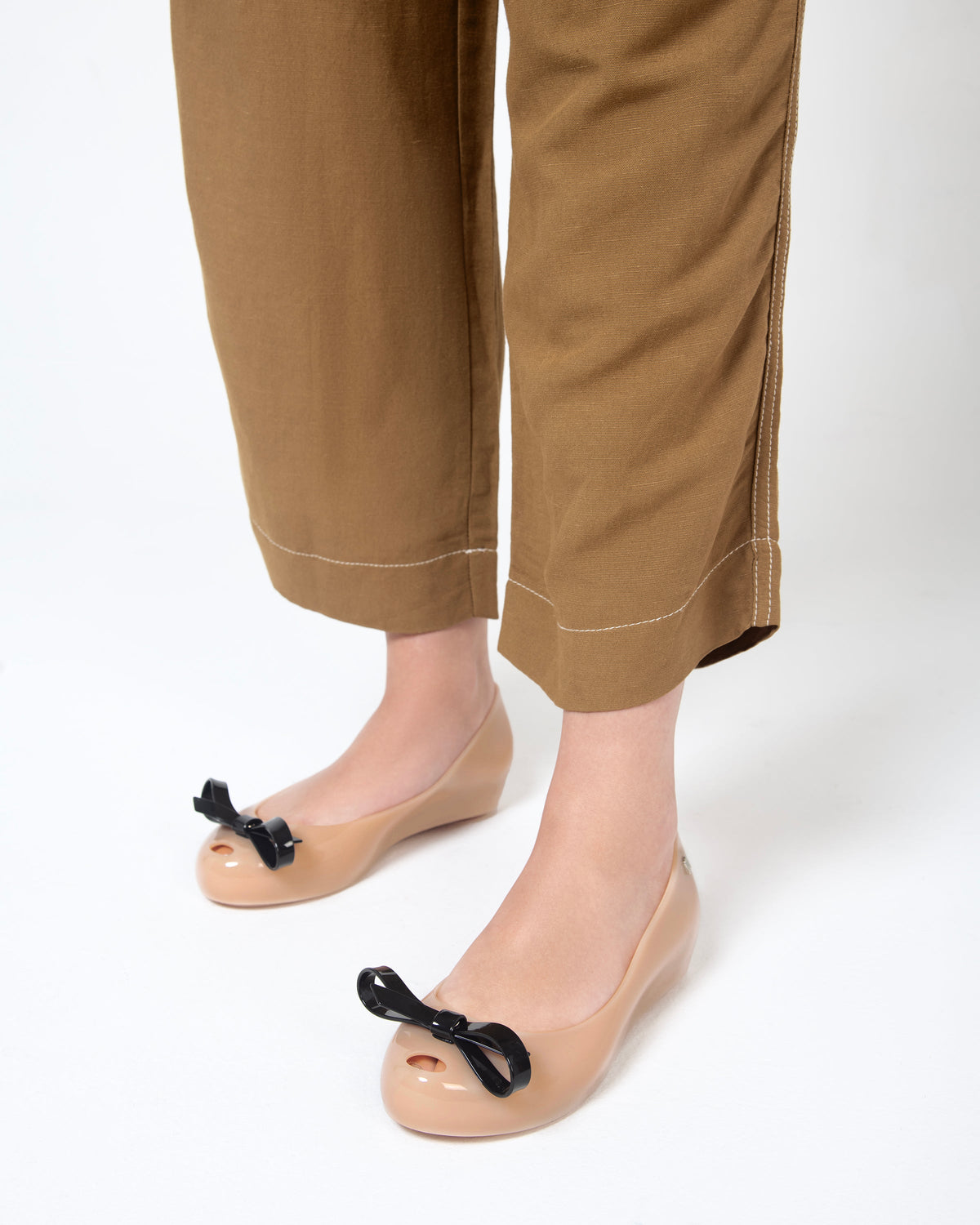 Model's legs in pants wearing a pair of black Ultragirl Bow flats