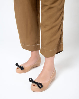 Model's legs in pants wearing a pair of black Ultragirl Bow flats
