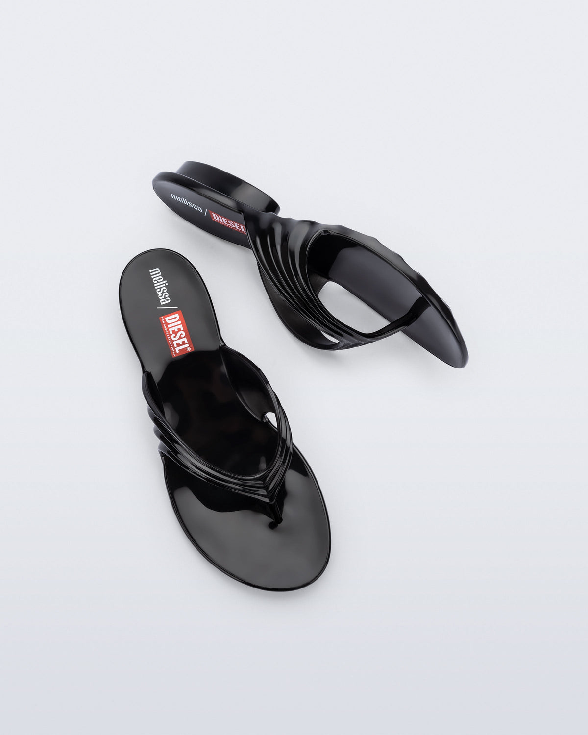 Top and side view of a pair of black Flip Flop + Diesel sandals