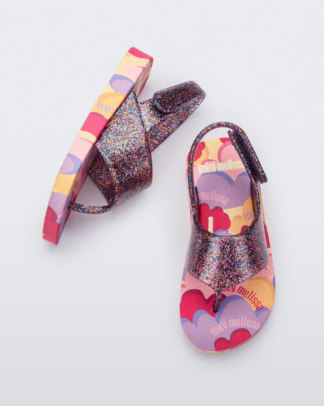 Top and side view of a pair of lilac glitter Shiny baby sandals with multicolor sole
