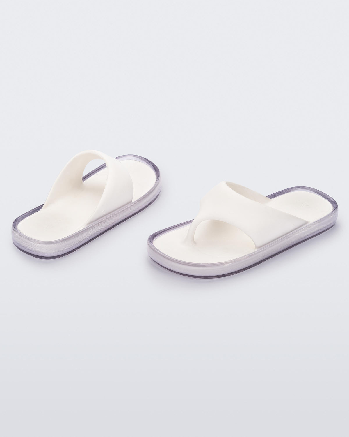 Angled view of a pair of white with clear sole Float flip flops