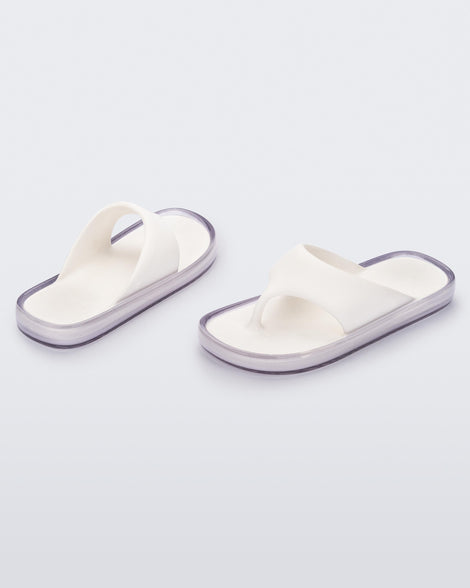 Angled view of a pair of white with clear sole Float flip flops