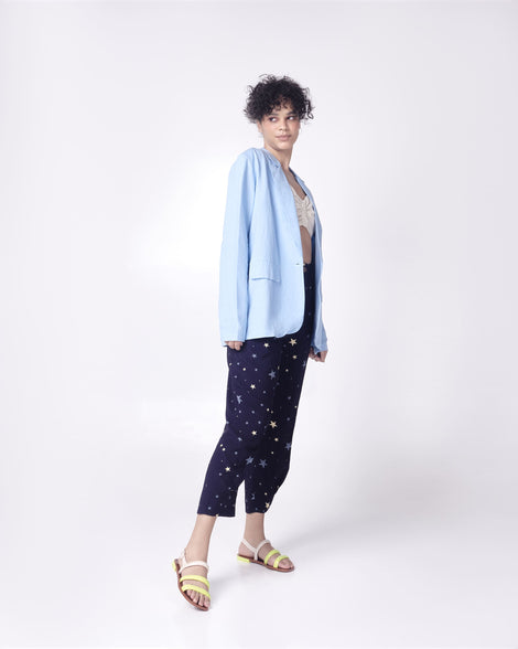 Model in a blue outfit wearing a pair of beige and yellow Essential Wave women's sandal with adjustable buckle.