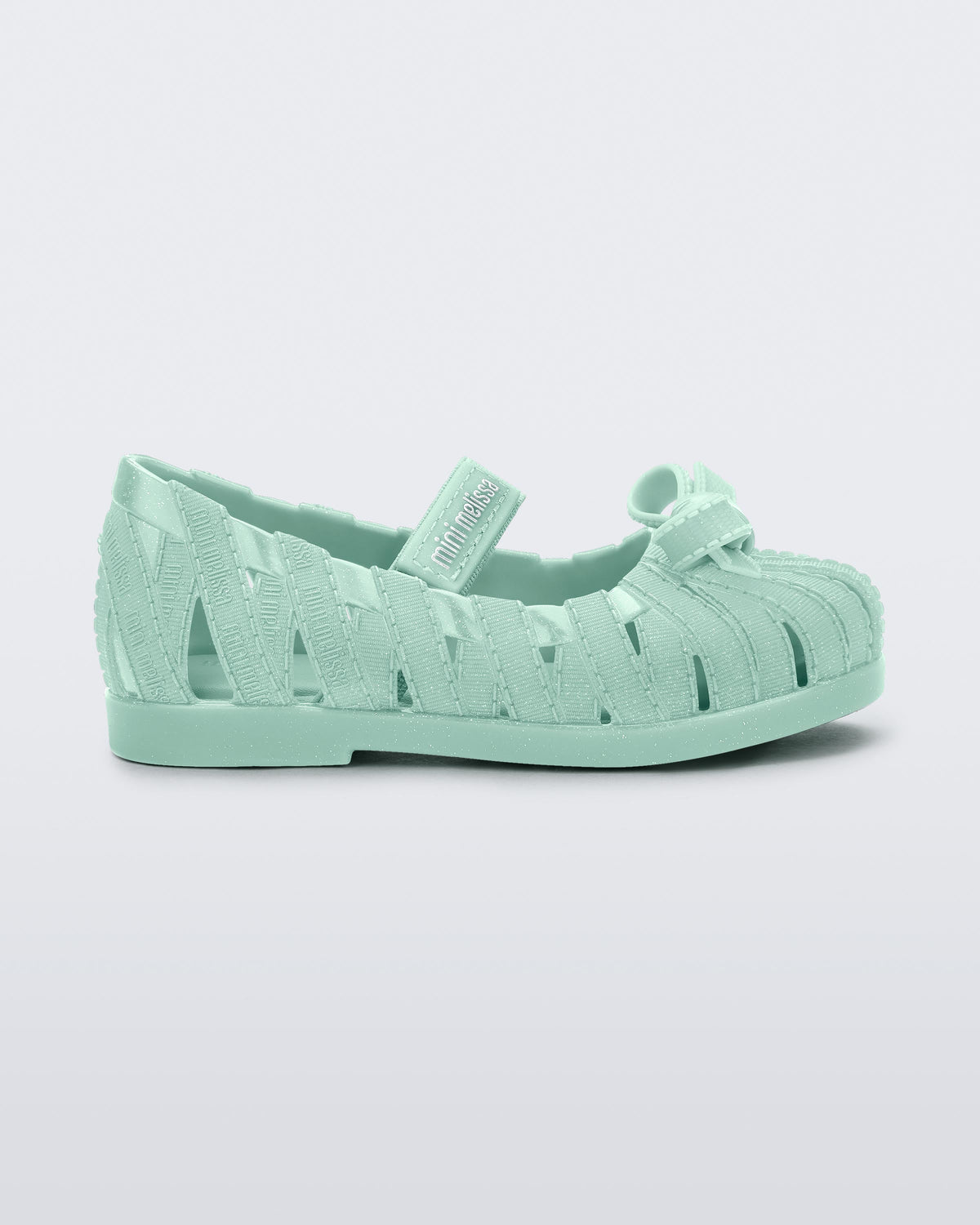 Side view of a glitter green M Lover Ballerina baby flat with bow and strap